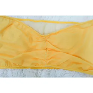 Detail view of yellow mesh tube top showing ruched center and textured fabric finish