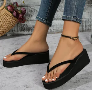 Detalle de las elegantes sandalias de cuña negras con suelas de plataforma gruesas en el modelo