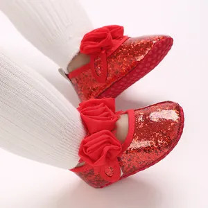 Detaillierte Ansicht roter Baby-Lauflernschuhe mit Glitzer und eleganten Stoffblumen