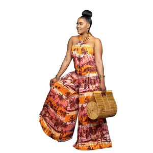 Detailed view of the tropical palm tree print on a halter neck backless wide-leg jumpsuit