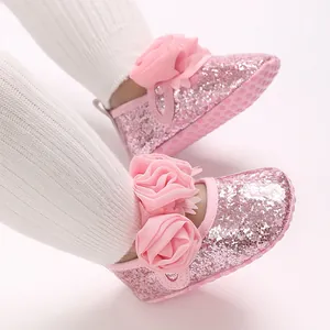 Detailansicht der rosa Glitzer-Babyschuhe mit Chiffon-Blumen und weichen Sohlen