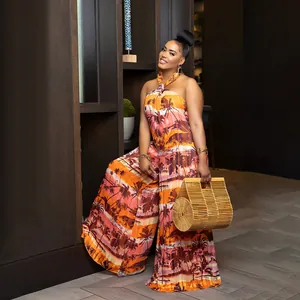 Model wearing tropical palm tree print halter neck backless wide leg jumpsuit