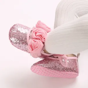 Detaillierte Ansicht von rosa Glitzer-Babyschuhen mit Stoffblumen und weicher Sohle