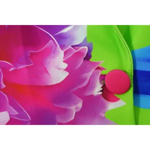 Macro detail of vibrant floral printed blazer fabric with a pink cloth-covered button