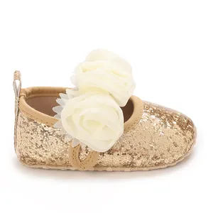 Detail showing baby gold glitter soft-sole walking shoes with white chiffon flowers