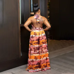 Back view of a halter neck backless jumpsuit with a tropical sunset palm tree print.