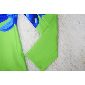 Close-up view of a lime green blazer sleeve with vibrant blue floral print detailing