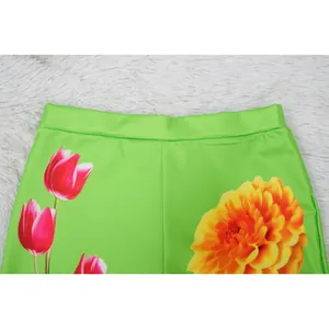 Close-up of vibrant pink and yellow floral print on bright green elastic waist fashion shorts