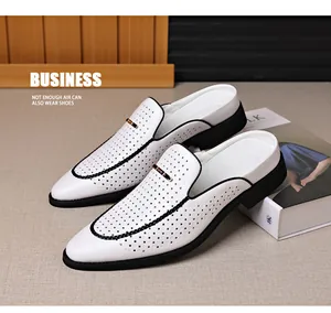 Primer plano de mules para hombre de cuero blanco perforado con hebilla dorada.