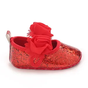 Detailed view of red glitter baby shoes with rose flower decoration and soft sole