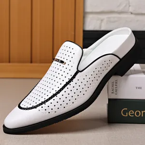 Detalle de mules para hombre de cuero blanco perforado con ribete negro y hebilla