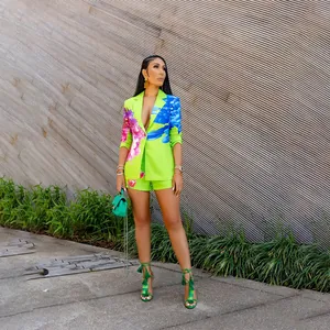 Full body view of model in fashion lime green floral blazer and matching shorts suit set