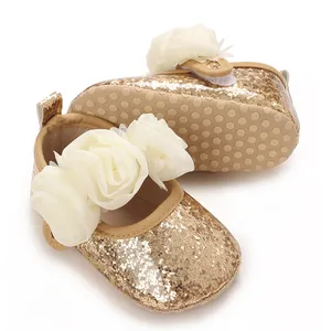 Detailansicht der goldenen Glitzer-Babyschuhe mit cremefarbenen Mesh-Blumenverzierungen