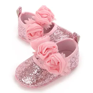Detailansicht rosa glitzernde Babyschuhe mit großen Stoffrosen-Verzierungen