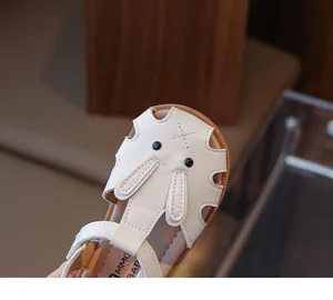 Detailopname van witte peutersandalen met een schattig konijnengezicht en zachte zool.