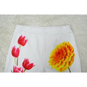 Detailed close-up of white fabric waistband featuring red tulips and yellow flower print