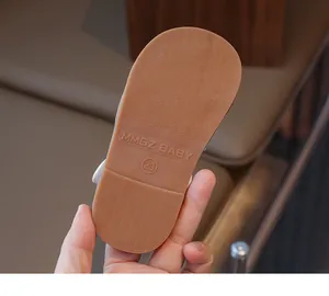 Detail van bruine antislip rubberen zool van babywandelsandaal met maatmerk