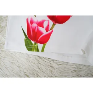 Close-up detail of neat stitching and vibrant tulip print on women's white floral suit hem