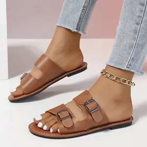 Elegante braune flache Pantoletten mit Doppelschnalle für Damen in einer Detailansicht