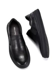 Detailweergave van zwarte lederen loafers met zachte textuur en instapontwerp.