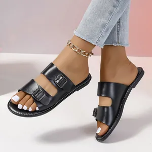 Nahaufnahme von schwarzen flachen Sandalen mit zwei Schnallen für Damen