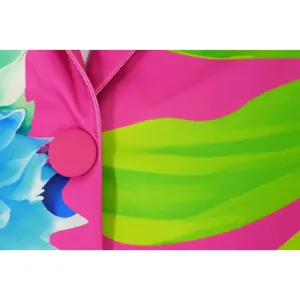 Macro detail of a pink fabric button on a vibrant floral print shawl collar blazer