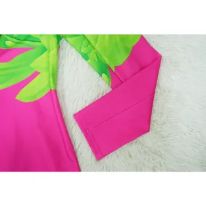 Close-up detail of vibrant pink long sleeve featuring a tropical green leaf print
