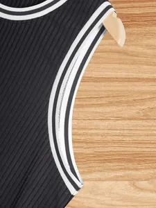 Detail view showing the ribbed knit texture and striped trim of a black slim fit tank top.