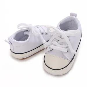 Vue détaillée de baskets en toile blanches pour bébé avec semelles en caoutchouc