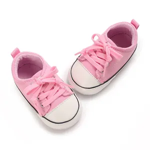 Vue détaillée de chaussures en toile rose pour bébé avec semelles souples.