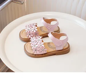 Detail of pink girls' sandals featuring leather flower appliques and rhinestones.