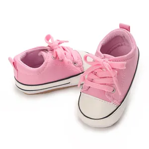 Gros plan de baskets en toile rose pour bébé avec semelle souple pour les premiers pas