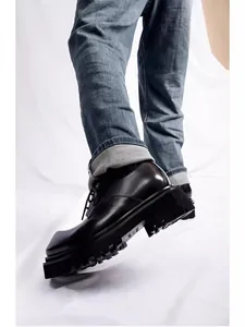 Detailansicht schwarzer Leder-Derby-Schuhe mit quadratischer Kappe und Plateausohle