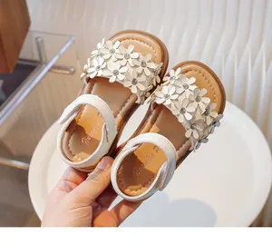 Close-up view of white girls' sandals featuring 3D flower petals and soft tan soles.