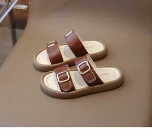 Detailansicht schicker brauner Mädchensandalen mit Gold-Schnallen und weißer Sohle
