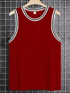 Red knitted ribbed tank top with striped trim hanging on a wooden hanger.