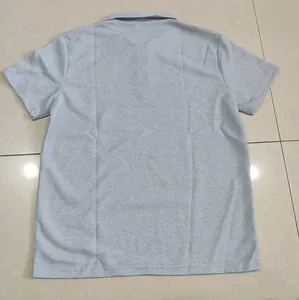 Vue arrière d'un polo gris pour homme en maille gaufrée posé sur un sol carrelé