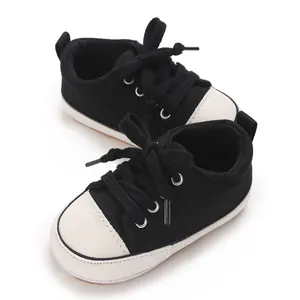 Gros plan sur des baskets classiques en toile pour bébé, noir et blanc, semelle souple.