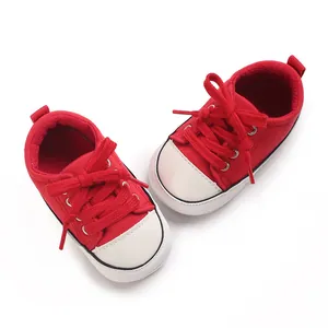 Vue détaillée de dessus des baskets classiques en toile rouge pour bébé à semelle souple.