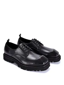 Detailansicht der schwarzen Leder-Derby-Schuhe mit eckiger Zehenpartie und dicker Sohle.