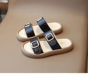Detailansicht der schwarzen Sandalen für Mädchen mit Goldschnallen und weichen Sohlen.
