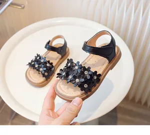 Close-up detail of black girl's princess sandals with 3D flower and rhinestone embellishments