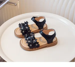 Detail view of girls' black floral sandals with sparkling rhinestone accents in black.