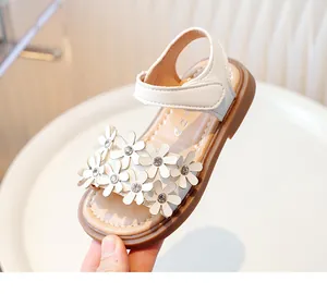 Detailed view of girl's white sandals with daisy flower and rhinestone embellishments