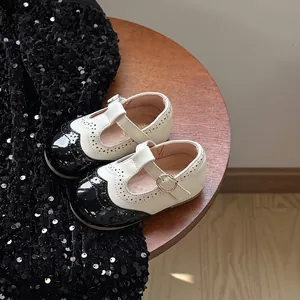 Vista dettagliata delle scarpe Mary Jane da neonata con motivi brogue e punta nera