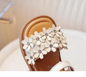 Close-up detail of white flowers and rhinestones on girls' summer sandals