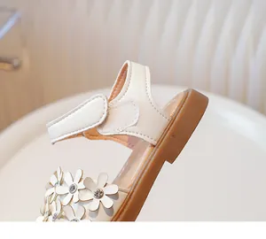 Close-up of girls cream sandals featuring 3D floral accents and a convenient velcro strap