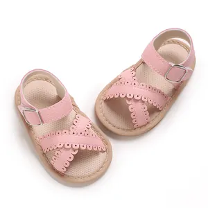 Detailed close-up of pink toddler girl sandals featuring scalloped cross straps and buckles