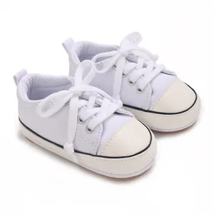 Vue détaillée de chaussures en toile pour bébé blanches avec bout en cuir ultra résistant