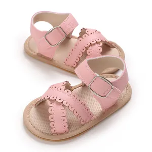 Detailed view of pink infant sandals with scalloped edges and silver buckle closure